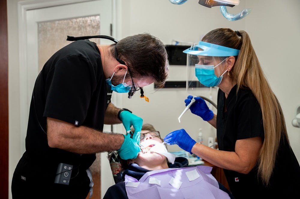 Together with dental assistant are treating an elderly patient - Dental Implants Together with dental assistant are treating an elderly patient - Dental Implants
