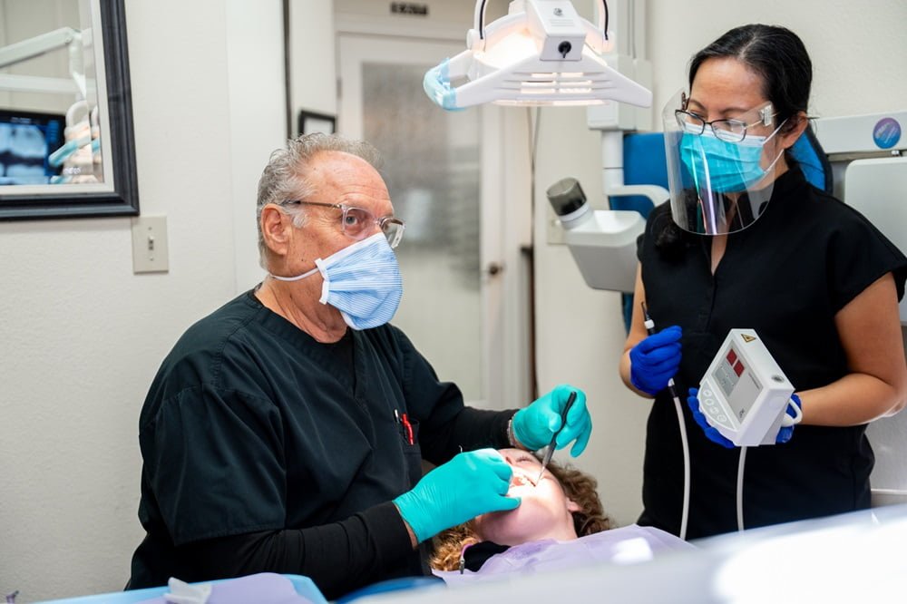 Dr. Chris Gipe, DDS/Owner of Dental Wellness of Los Alamitos together with her assistant performing a treatment to a patient - orthodontics Dr. Chris Gipe, DDS/Owner of Dental Wellness of Los Alamitos together with her assistant performing a treatment to a patient - orthodontics