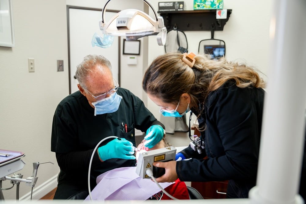 Dr. Chris Gipe and dental assistant perform a procedure on a patient in a dental clinic - Cosmetic dentistry Dr. Chris Gipe and dental assistant perform a procedure on a patient in a dental clinic - Cosmetic dentistry