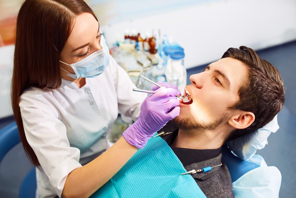 Receptionist Lyndsay at a dental office attentively listens to a patient at the front desk - dental crowns and bridges